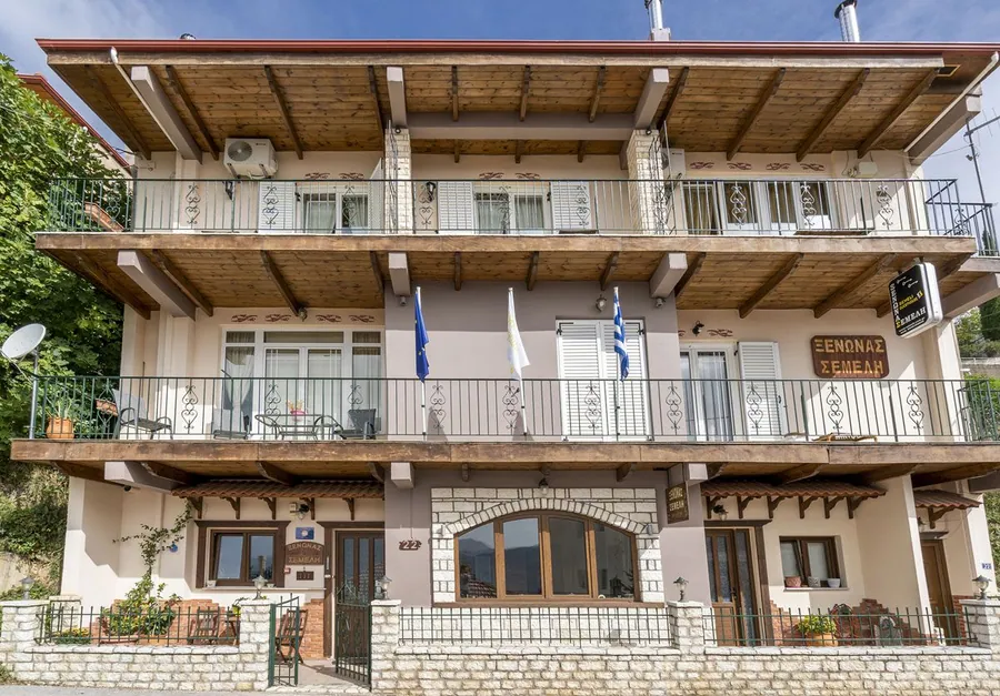 Ο τριώροφος ξενώνας με τα μπαλκόνια και την πέτρινη βάση